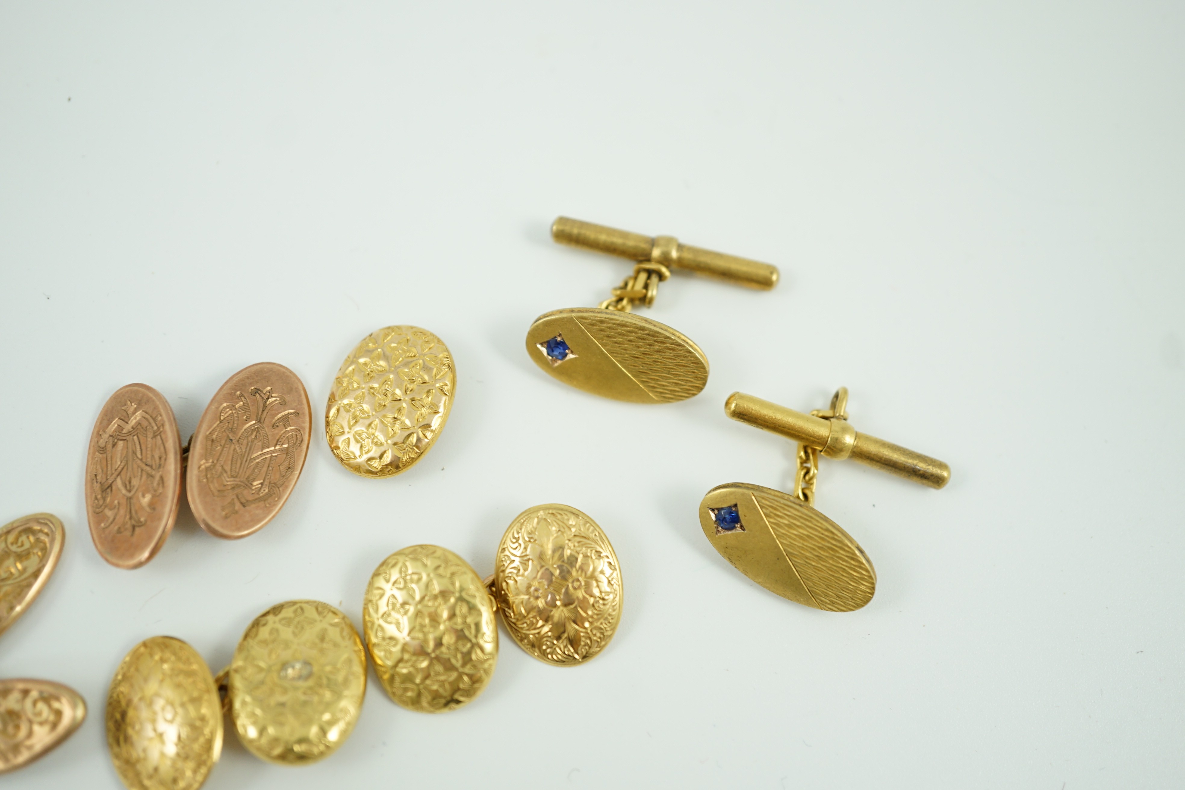 A pair of late Victorian engraved 15ct gold oval cufflinks, one other similar link section only, 6.7 grams, a pair of gem set 585 cufflinks, gross 6.5 grams and two 9ct gold cufflinks, 5.9 grams.